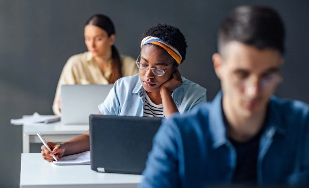 Student concentrating on written work during an exam