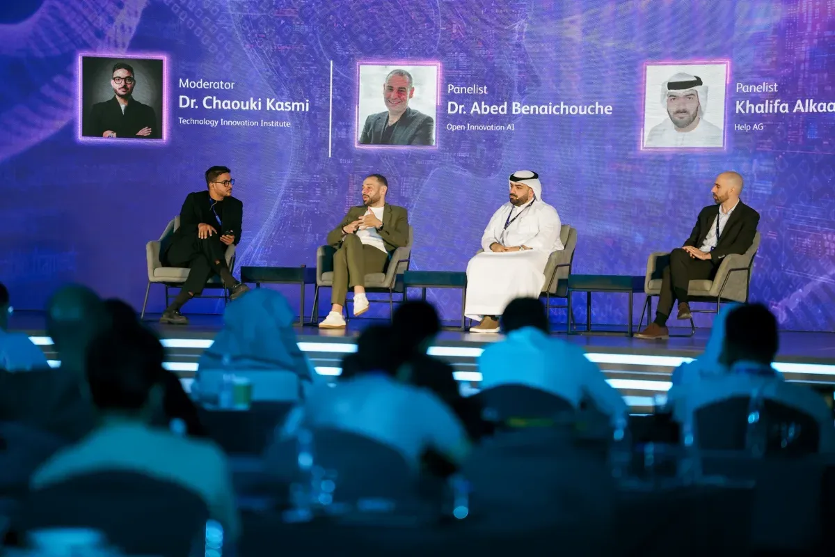 A four-person panel on stage at the UAE AI Expo, speaker names on the screen behind them.